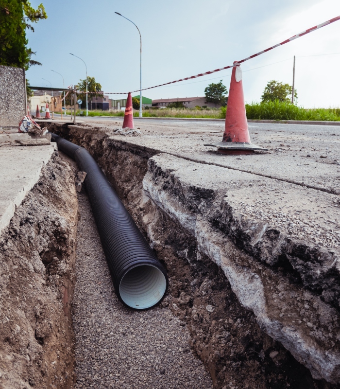 Travaux d’assainissement avec pose de canalisation enterrée dans une tranchée sécurisée.