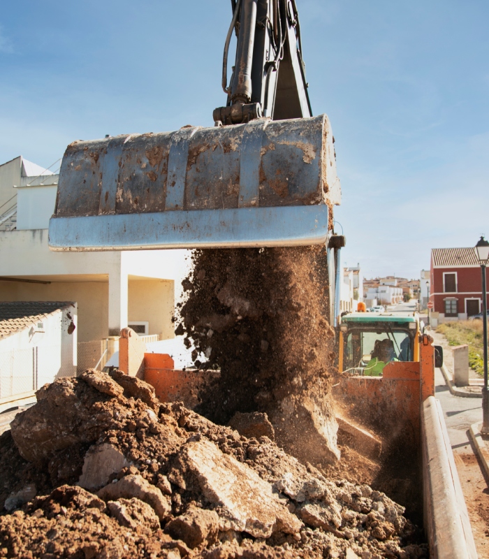 Chargement de terre et gravats par pelle mécanique lors d’un chantier de terrassement.
